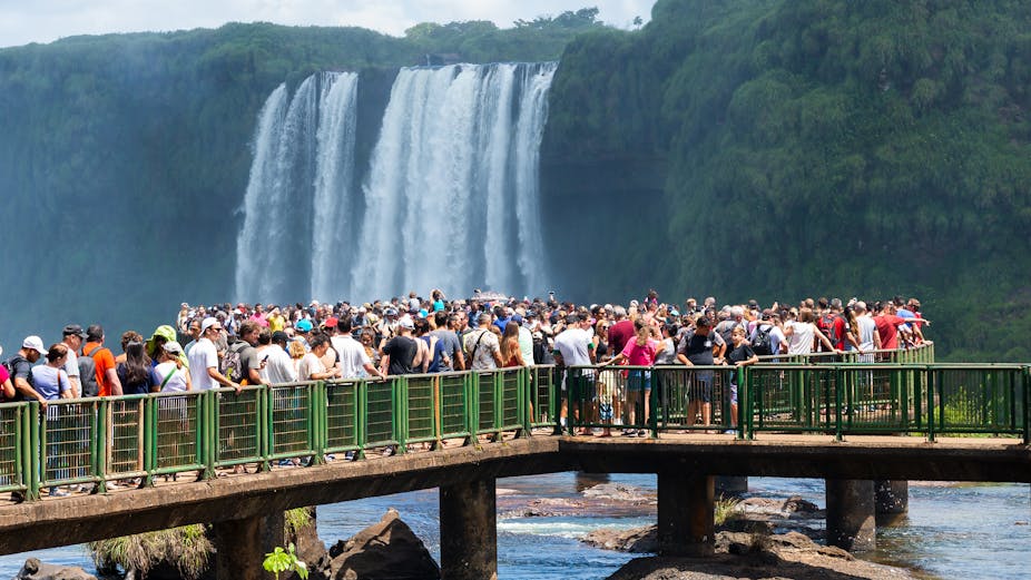 Technology has played a significant role in the rise of overtourism, transforming travel through the internet and social media, which blur the lines between locals and tourists and elevate previously little-known destinations. While historical transportation advancements drove mass tourism, current effects are more subtle, with digital nomadism and online platforms like Airbnb reshaping travel habits. AI may offer solutions, such as creating personalized travel experiences and managing tourist flow, but its overall impact on tourism remains uncertain. Ultimately, factors like climate change and economic pressures may weigh heavier on future travel patterns than technology alone.