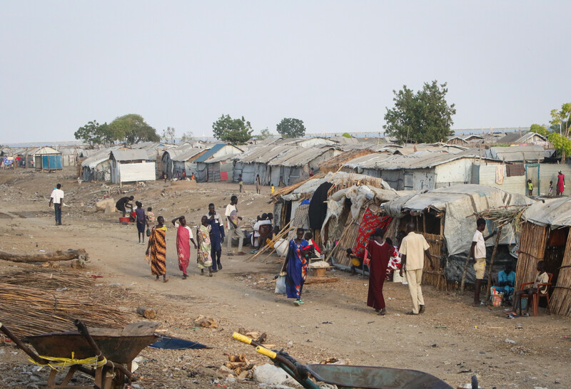 South Sudan's protection sites, initially established as temporary shelters during conflict, have evolved into long-term camps for hundreds of thousands reliant on diminishing aid. To address this crisis, a shift from short-term emergency relief to sustainable, development-driven recovery is necessary. Key actions include enhancing access to land, restoring housing, and fostering local peace dialogues. International support should align with national priorities and focus on flexible funding, coordination between sectors, and investments in infrastructure. Effective solutions are critical to prevent prolonged dependency and to enable recovery and reintegration.