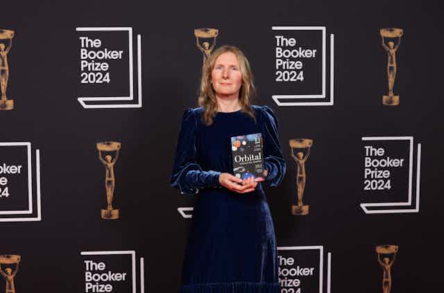 Samantha Harvey's novel "Orbital" has won the 2024 Booker prize. The story explores the human cost of space flight in the face of the climate crisis. Set on the International Space Station during a typhoon in southeast Asia, the book delves into the astronauts' detachment from Earth and their contemplation of the planet's vulnerability. Harvey's prose highlights the tension between longing for the familiarity of Earth and the ambition to leave it behind. The novel serves as a poignant reminder of the urgency to save the planet as billionaires prioritize interplanetary exploration.
