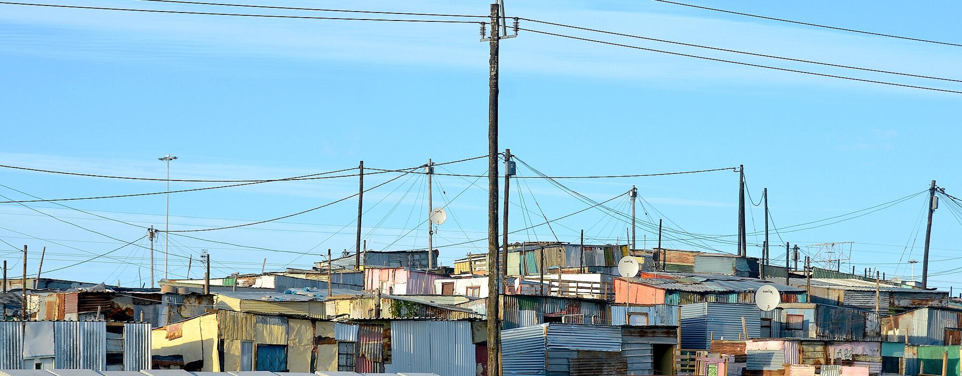South Africa's housing policy is misaligned due to the inclusion of Solar Home Systems (SHS) in housing grants, initially intended to alleviate energy poverty during power outages. Despite the urgency at the time, funding SHS diverted resources from essential housing projects without a sustainable plan. Recent improvements in Eskom’s capacity have rendered the SHS policy less relevant, yet it persists. A study shows SHS units have minimal impact on reducing grid demand or energy poverty in low-income households, highlighting significant opportunity costs that hinder crucial housing development amid ongoing shortages.